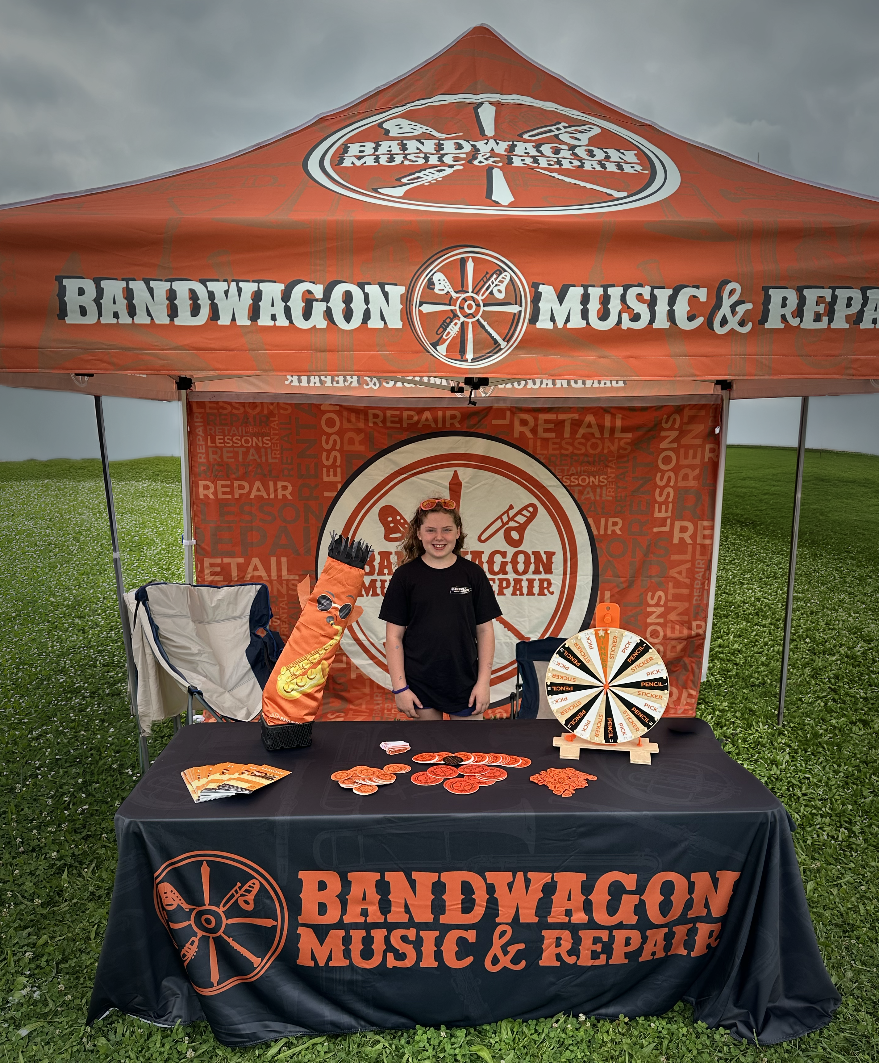 Bandwagon Music & Repair branded event booth with custom canopy, signage, and promotional materials.